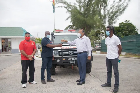 Minister of Health Dr Frank Anthony (at right) presents the keys for the ambulance to Region Nine Agriculture Officer Darren Halley as other officials look on (DPI photo) 