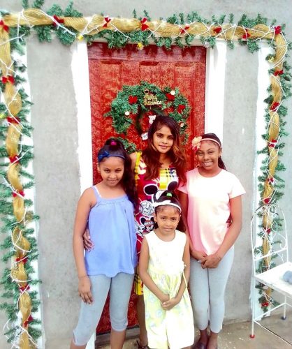 Angelha Dhuman and her three daughters in their new home, showing their Christmas decorations with fairy lights
