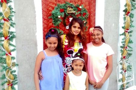 Angelha Dhuman and her three daughters in their new home, showing their Christmas decorations with fairy lights
