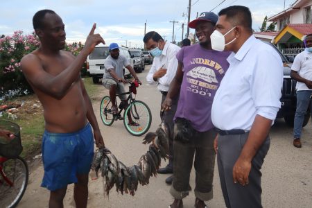 Residents of Clonbrook, Bee Hive and Ann’s Grove on the East Coast of Demerara yesterday met with Agriculture Minister, Zulfikar Mustapha during an outreach.
In this Ministry of Agriculture photo, a fisherman, catch in hand, engages with the Minister (right).