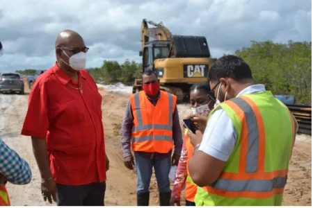 Minister of Public Works, Juan Edghill (left) speaks with the contractor responsible for roadworks leading to St. Cuthbert’s Mission. (DPI photo)
