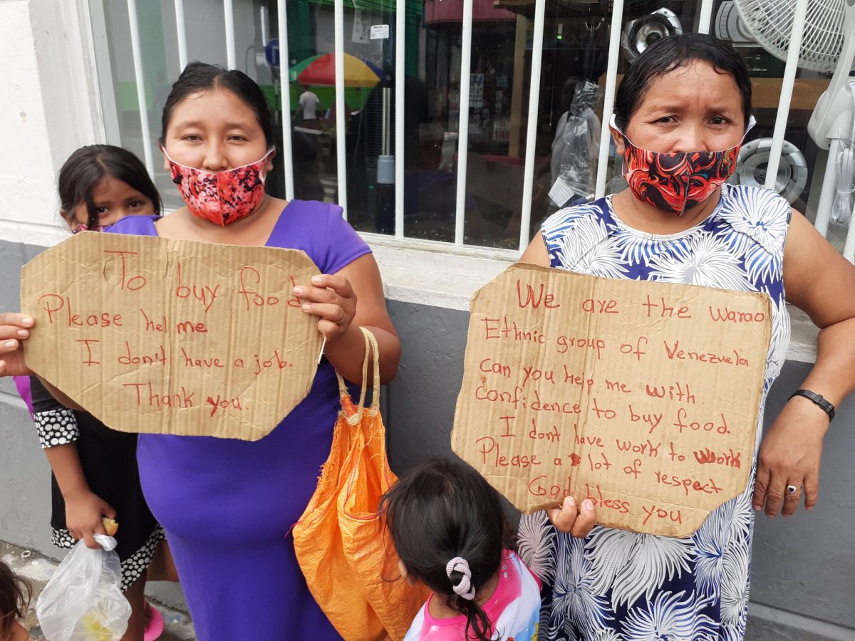 Two Warao women and their children beg for assistance to buy food on High Street, San Fernando yesterday.