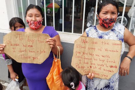 Two Warao women and their children beg for assistance to buy food on High Street, San Fernando yesterday.