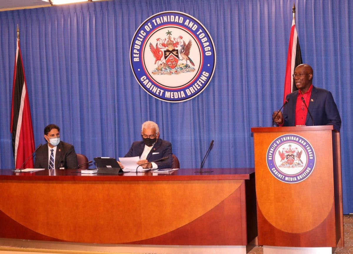 Prime Minister Dr Keith Rowley addresses the media during yesterday’s COVID-19 briefing at the Diplomatic Centre, Port-of-Spain. Also in the picture are Chief Medical Officer Dr Roshan Parasram and Health Minister Terrence Deyalsingh.