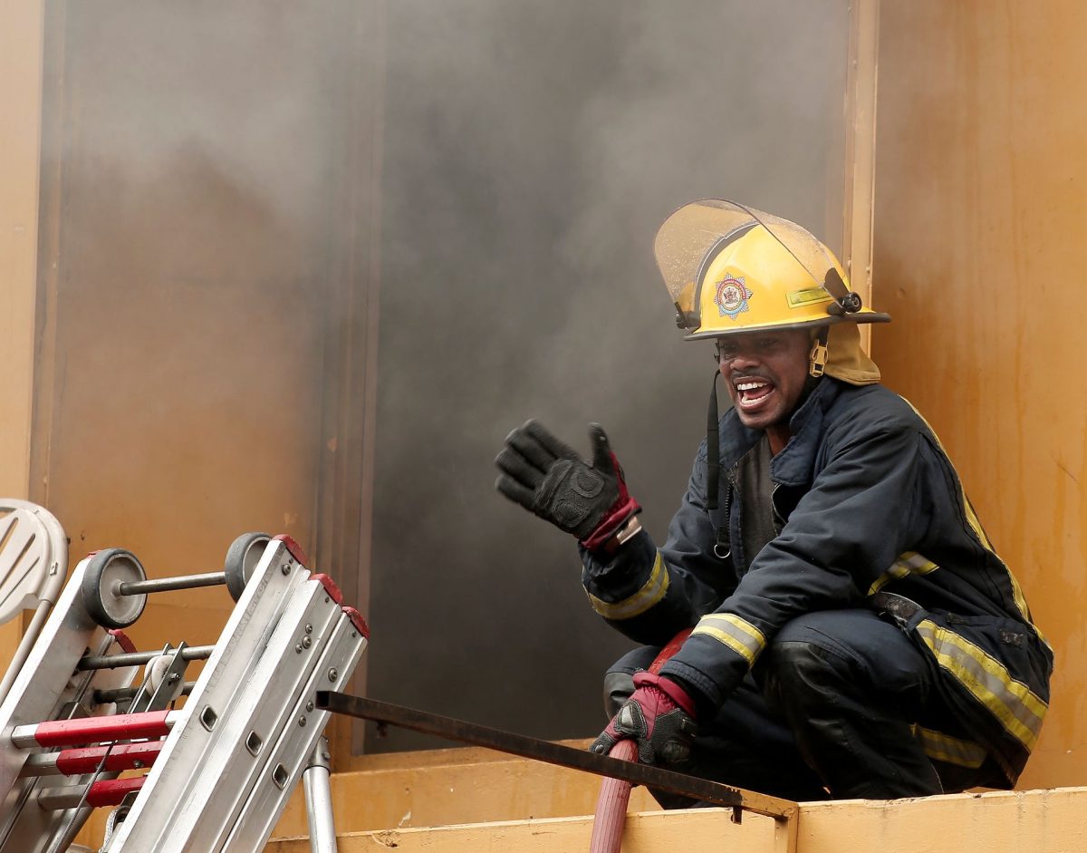 A fire officer issues instructions to his colleagues during the fire along Independence Square, Port-of-Spain, yesterday.