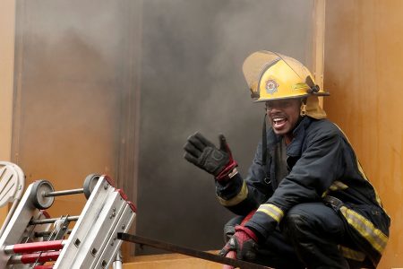 A fire officer issues instructions to his colleagues during the fire along Independence Square, Port-of-Spain, yesterday.