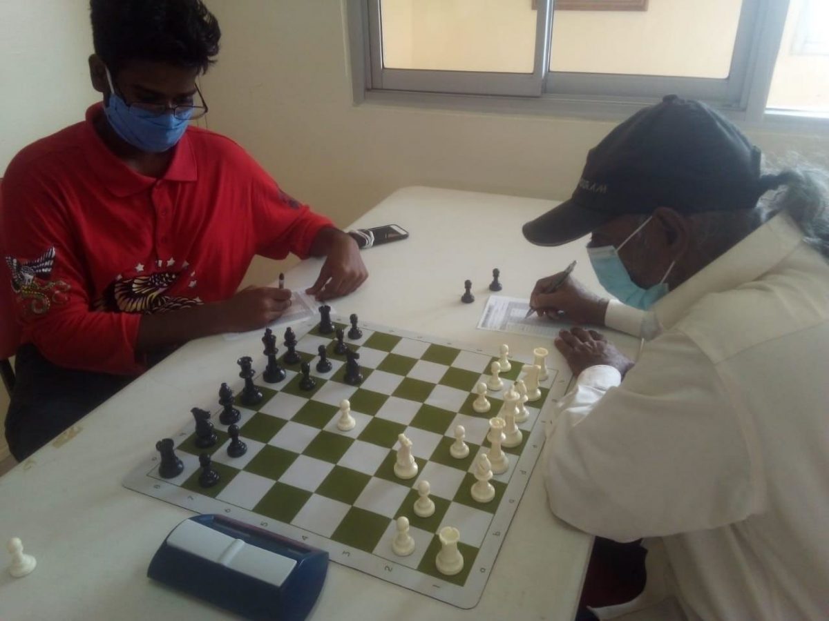 Undefeated, Joshua Gopaul (left) is locked in battle with veteran Rai Sharma during the December National Chess Championships.