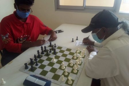 Undefeated, Joshua Gopaul (left) is locked in battle with veteran Rai Sharma during the December National Chess Championships.