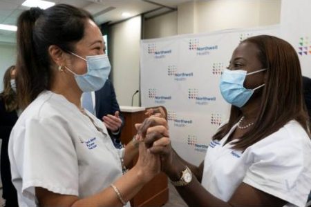 Nurse Annabelle Jimenez (left) congratulates colleague Sandra Lindsay after she was inoculated with the Pfizer-BioNTech COVID-19 vaccine at the Jewish Medical Center in the Queens borough of New York on Monday.