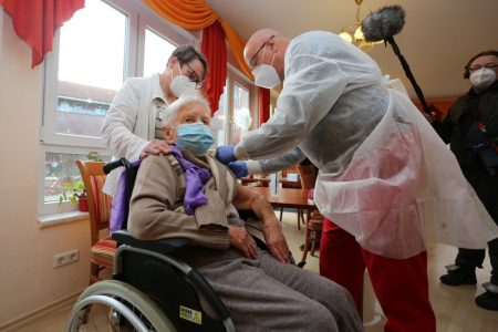Edith Kwoizalla, 101 years old, receives the first vaccination against the novel coronavirus COVID-19 by Pfizer and BioNTech from Doctor Bernhard Ellendt (R) in a senior care facility in Halberstadt (Seniorenzentrum Krueger), central northern Germany, on December 26, 2020. (AFP/Matthias Bein / dpa )