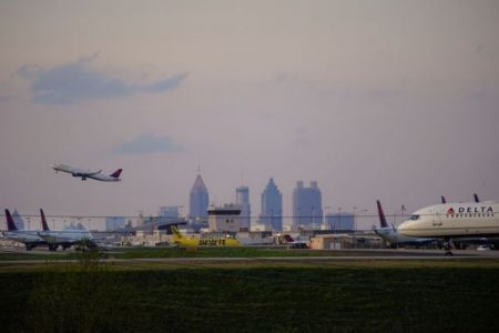 FILE PHOTO: The Atlanta skyline is seen behind Delta Air Lines passenger planes on a runway where they are parked due to flight reductions made to slow the spread of coronavirus disease (COVID-19), at Atlanta Hartsfield-Jackson International Airport in Atlanta, Georgia,  U.S. March 21, 2020. Picture taken March 21, 2020.  REUTERS/Elijah Nouvelage