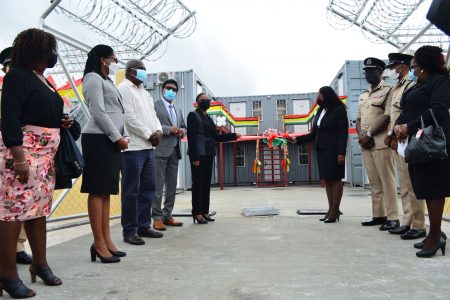 Acting Chancellor of the Judiciary, Justice Yonette Cummings-Edwards (right) and Acting Chief Justice Roxane George-Wiltshire cutting the ribbon at the opening of the container courts at Lusignan. (Orlando Charles photo)