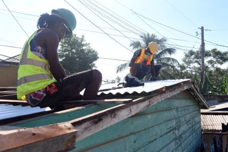 Jermaine McKay (right) and Garfield Campbell volunteered their time and skill to install a new roof on the house of Dwayne Walker and his wife, Staniece, in Ellerslie Pen, Spanish Town, on Wednesday. The couple’s heart-tugging story of love and their ordeal under a leaky roof sparked admiration and offers of charity after a Gleaner video went viral.