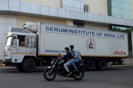Men ride on a motorbike past a supply truck of India's Serum Institute, the world's largest maker of vaccines, which is working on a vaccine against the coronavirus disease (COVID-19) in Pune, India, May 18, 2020. REUTERS/Euan Rocha/File Photo