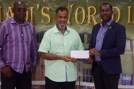Managing Director of Mohamed’s Enterprises, Nazar Mohamed (centre) presents a sponsorship cheque to President of the Guyana Football Federation (GFF), Wayne Forde (right) as Aubrey ‘Shanghai’ Major looks on.