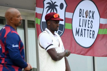 Jason Holder (right) and Phil Simmons with a BLM banner (Getty photo)