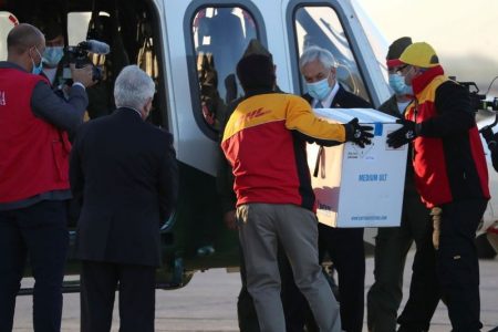 Chile's President Sebastian Pinera looks as workers carry the first batch of the Pfizer-BioNTech COVID-19 vaccine to a helicopter, as the coronavirus disease (COVID-19) outbreak continues, at the Santiago International Airport, in Santiago, Chile December 24, 2020. REUTERS/Ivan Alvarado