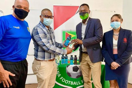 GFF Executive Committee member Dion Inniss (second from right) receives the donation from Banks DIH Waters Beverage Brand Manager Colin King in the presence of head-coach Marcio Maximo (first from left) and GFF Marketing Committee chair Lisa Ahmad.