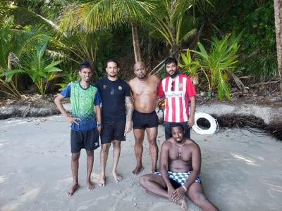 SAFE ON LAND: Police constable Kevin Sampson, standing second from right, at Mon Poui Beach, Blanchisseuse, with four doctors, two of whom were rescued by Sampson and PC Quincy Quintero after they became stranded on a rock out at sea on Thursday.