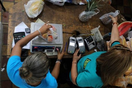 Workers weigh goods in an open-air fruit and vegetable market in Caracas, Venezuela December 22, 2020. REUTERS/Manaure Quintero