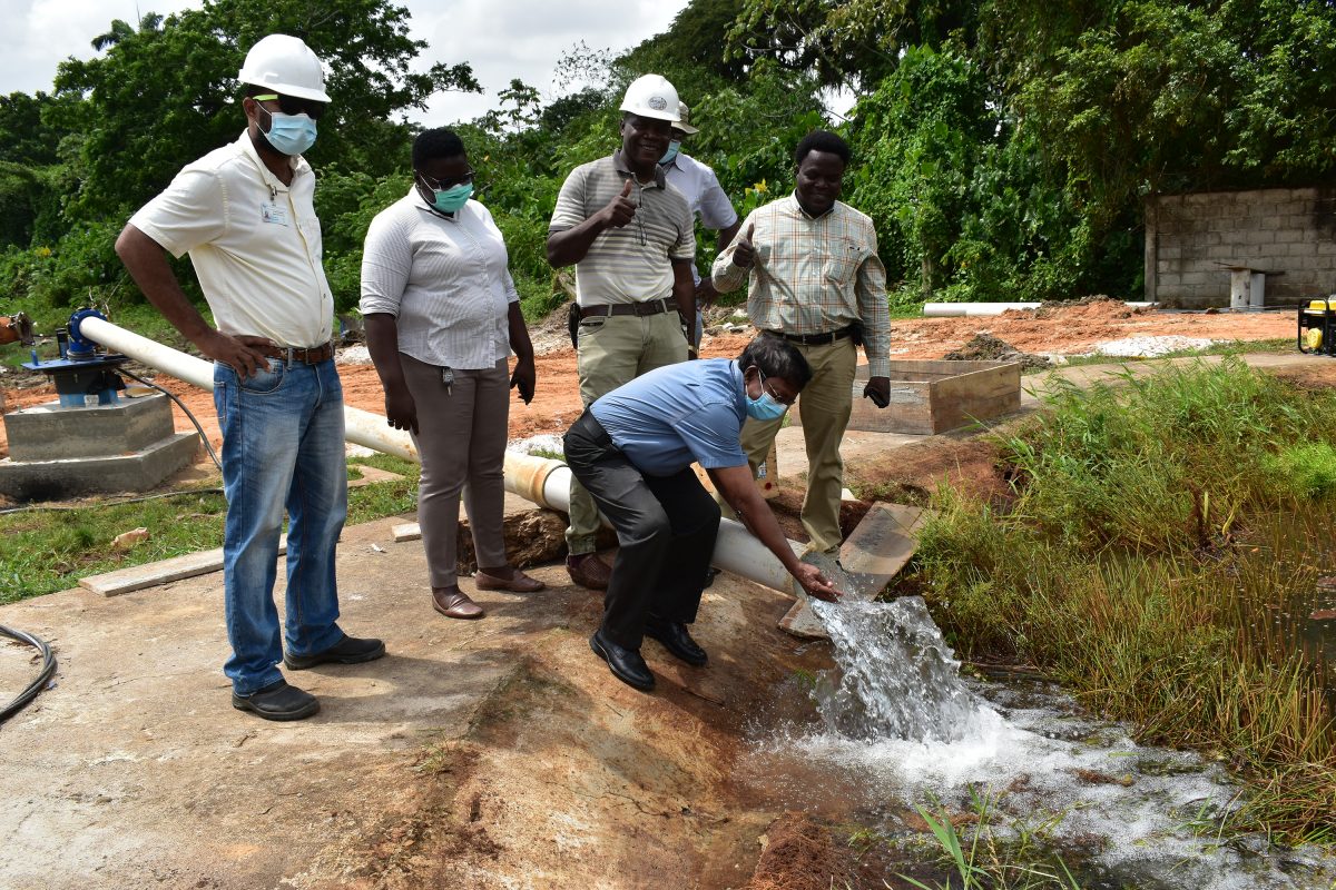 GWI CEO Shaik Baksh sampling water from the well (GWI photo)