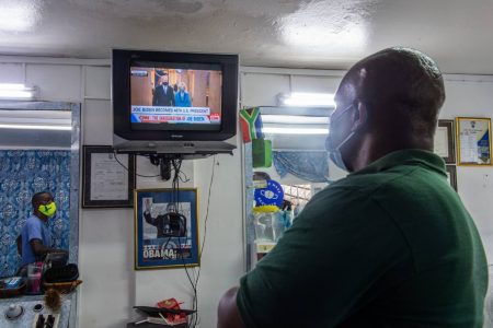 Christopher Reid, who works at A Class Barbers in Mona, St Andrew, watches the inauguration ceremony for Joseph Biden as the 46th president of the United States of America on Wednesday. Jamaicans’ interest in the new administration has been piqued by Vice-President Kamala Harris, who has ancestral roots in the parish of St Ann.
