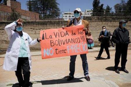 FILE PHOTO: Medical workers hold a sign that reads "The life of Bolivians is priceless" as they attend a protest demanding the authorities for a rigid quarantine, amid the coronavirus disease (COVID-19) outbreak, in La Paz, Bolivia January 27, 2021. REUTERS/David Mercado/File Photo