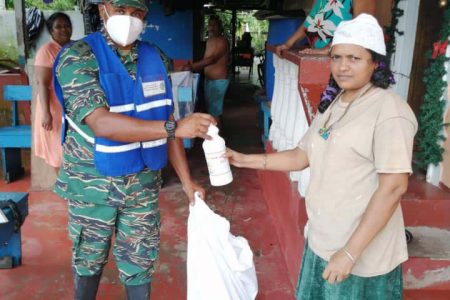 A member of the CDC (at left) presenting a hamper to one of the families affected by the flooding. (CDC photo)
