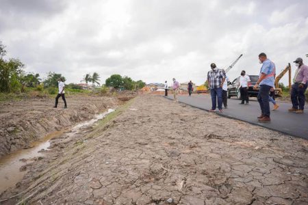 President Irfaan Ali and Minister of Housing and Water Collin Croal inspecting the work done on a section of the asphalted road between Eccles to Diamond (Office of the President photo)
