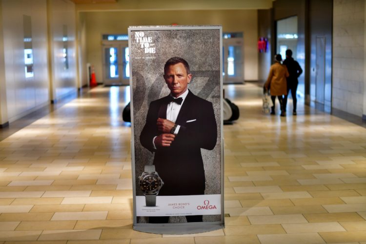 FILE PHOTO: Shoppers walk past an advertisement for the upcoming James Bond film "NO TIME TO DIE" whose release has been delayed to October, at the Christiana Mall in Newark, Delaware U.S. November 19, 2020. REUTERS/Mark Makela/File Photo