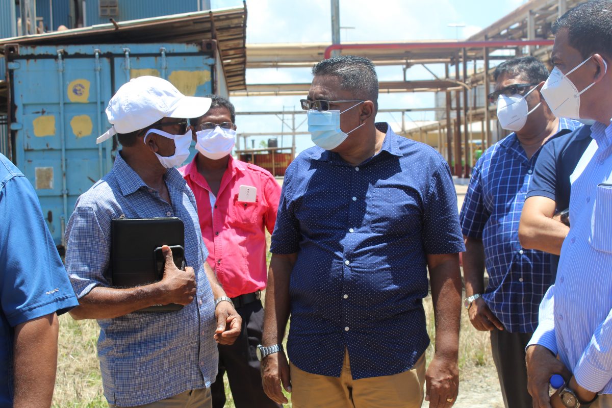 Minister of Agriculture, Zulfikar Mustapha (centre) interacting with Vishnu Panday (left) during a visit to Skeldon Estate last year. Looking on (second from right) is Region Six Chairman, David Armogan