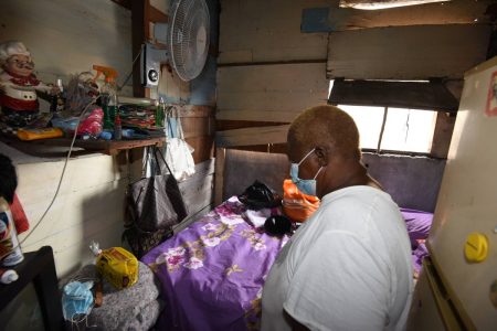 Jean Lamey shows the inside of her small one-bedroom shack located inside a dilapidated building on Hanover Street in downtown Kingston. The building is in dire need of repairs and is home to a number of families.
