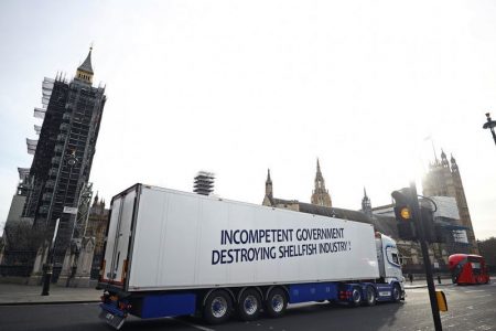 A lorry with a sign in protest against post-Brexit bureaucracy that hinders exports to the European Union, drives at the Parliament Square in London, Britain, 18 January 2021. REUTERS/Hannah McKay