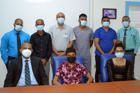 Aditya Mohabir (seated at centre), with his mother, Nadie Budwah (seated on right), Minister of Health Dr Frank Anthony (seated at left) and the team of doctors who performed the transplant (Orlando Charles photo)