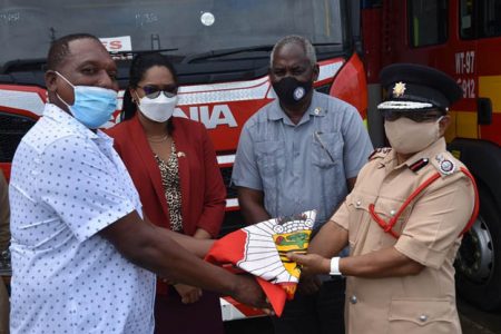 The handing over of the ceremonial colours of the GFS from Marlon Gentle (at left) to Kalamadeen Edoo (Ministry of Home Affairs photo)