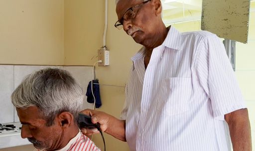 Ramsaran Moonsammy cutting his son's hair.