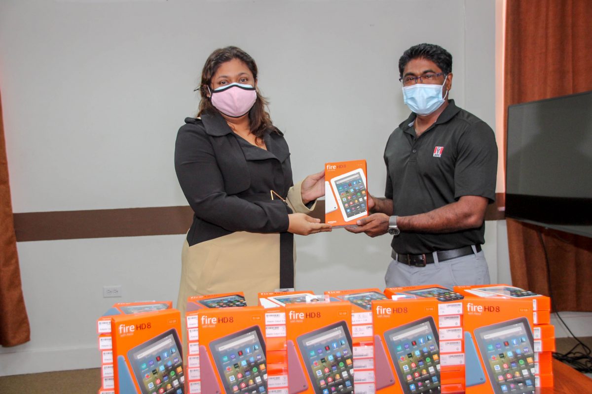 Minister of Education Priya Manickchand (left) receiving the tablets on behalf of the Ministry from General Manager of KFC Guyana Paul Subryan. (Ministry of Education photo)