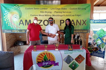 Patanjalee `Pur’ Persaud (left) accepts the cheques from CEO of Amazon Planx Amit Persaud and Corporate Liaison of AgroServices Renuka Singh.
