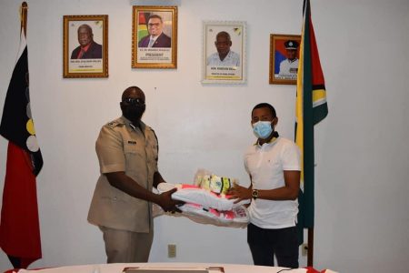 Kemol Savory (right) receives his gear from Commissioner of Police, Nigel Hoppie, DSM.
