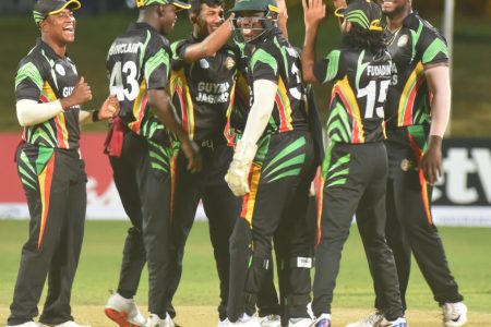 The Guyana Jaguars players celebrate the fall of a wicket.