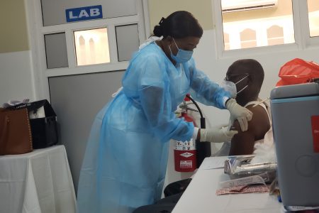 Dr Fawcett Jeffrey receiving his first dose of the Oxford AstraZeneca vaccine yesterday (Orlando Charles photo)