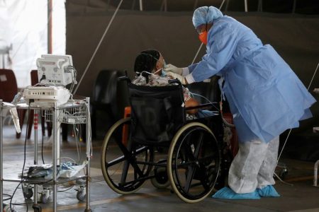 FILE PHOTO: A healthcare worker tends to a patient at a temporary ward set up during the coronavirus disease (COVID-19) outbreak, at Steve Biko Academic Hospital in Pretoria, South Africa, January 19, 2021. Phill Magakoe/Pool via REUTERS/File Photo