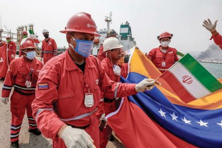 A Venezuelan oil worker holds up a small Iranian flag during a ceremony Monday for the oil tanker’s arrival at the El Palito refinery near Puerto Cabello, Venezuela. (AP/Ernesto Vargas)