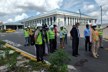 CJIA Expansion Project Manager Carissa Gooding explains to Minister of Public Works Juan Edghill some of the planned works during an one-site assessment of the project yesterday. (Marcelle Thomas photo)
