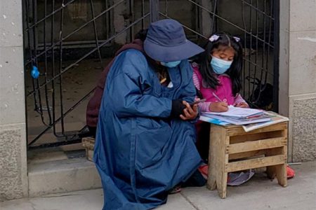 Jeanete Alanoca, who works at a cemetery, helps her daughter Neydy, a Bolivian primary school student, with her virtual classes during the outbreak of the coronavirus disease (COVID-19) at the Cementerio General cemetery in La Paz, Bolivia, March 16, 2021. Picture taken March 16, 2021. REUTERS/Santiago Limachi