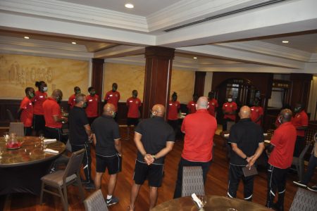 Players and coaching staff of the Golden Jaguars Senior Men's team in discussion at the hotel following their arrival in the Dominican Republic to compete in the 2022 FIFA World Cup Qualifiers.