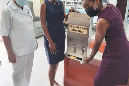 Dr Shivon Lewis-Isles (right) on behalf of Girls Inspire Girls, handing over the dispenser to Dr Whitney Munroe of the Oncology Clinic, as nurse Cecilia Bennie looks on.