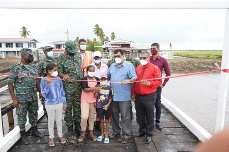 A young resident of the community cuts the ribbon at the Lesbeholden bridge handing over. (GDF photo)