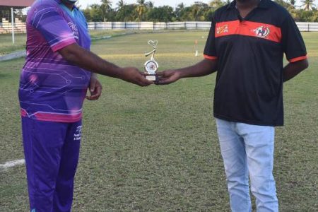 Permaul Mangali (left) receives his player of the match award from BMC Director, Timothy Bhagwandin.
