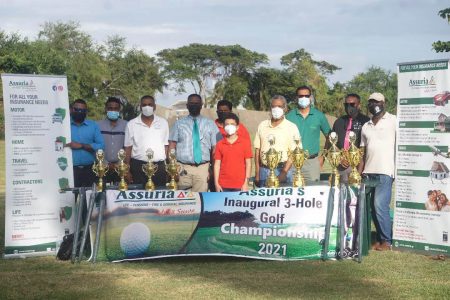 Former Prime Minister, Samuel Hinds (centre) along with Managing Director of Assuria, Yogindra Arjune pose with some employees of the company prior to the start of the tournament yesterday. (Emmerson Campbell photo)